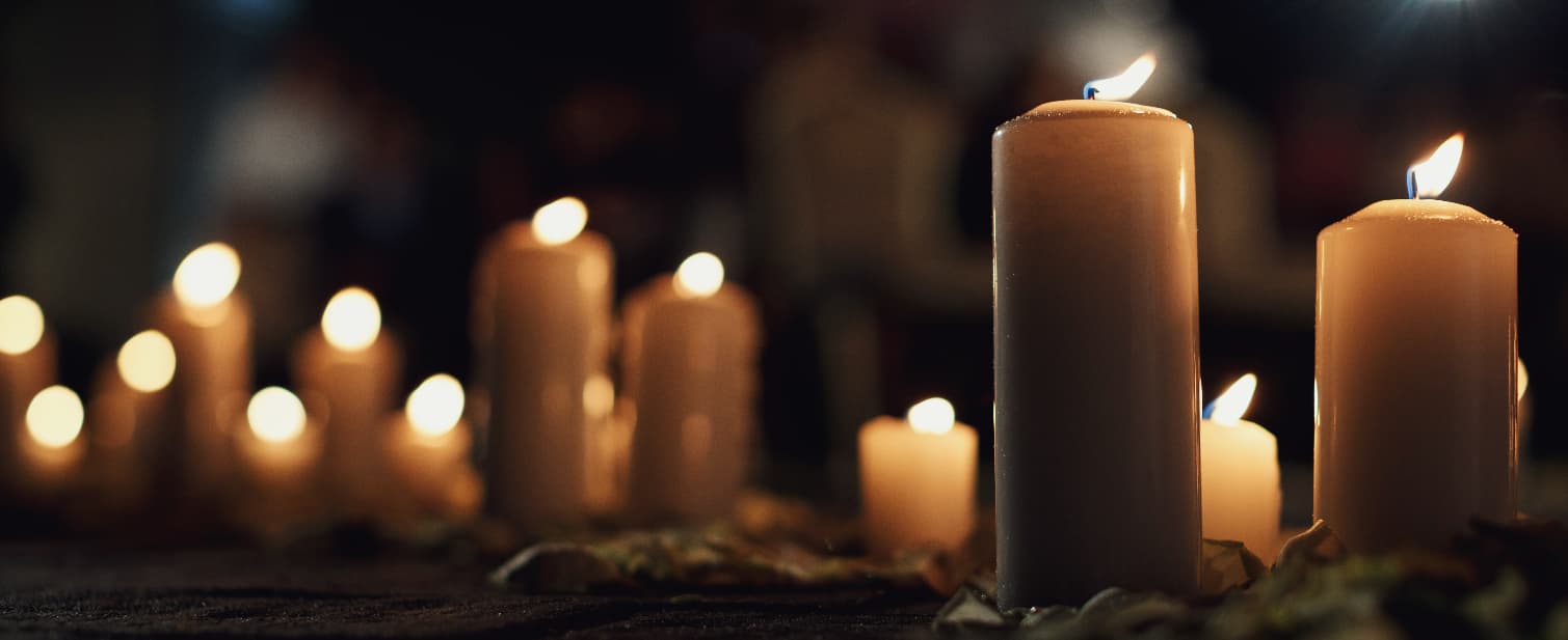Multiple lit luxury candles creating a warm and relaxing atmosphere in a softly lit outdoor setting