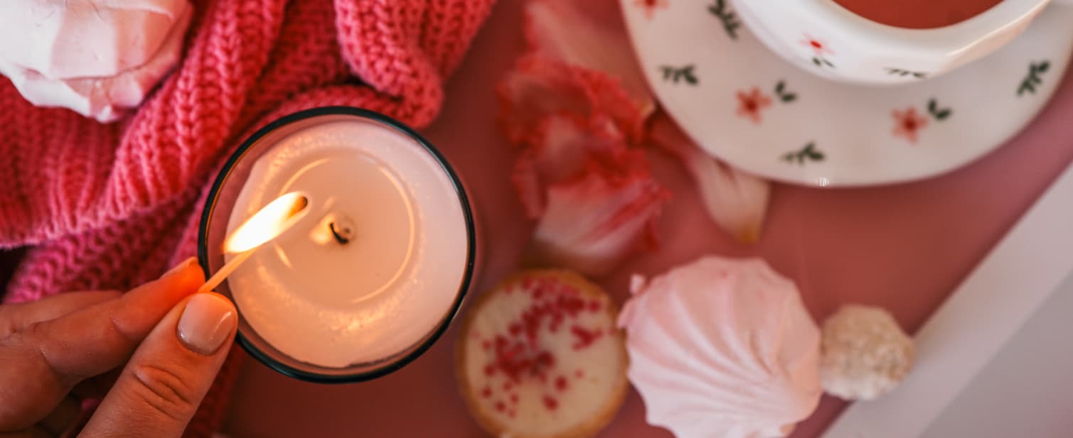 Luxury valentines day candle with flowers, tea and cosy blanket